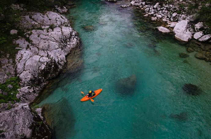 person on riding orange kayak on river